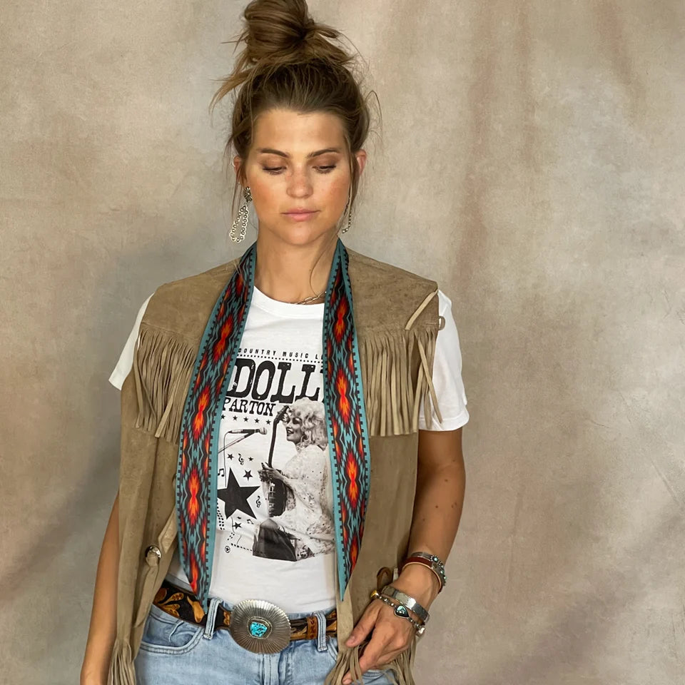 Nashville Twilly draped around neck over fringe vest, Dolly Parton tee, and silver concho belt