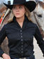 Woman wearing a black cowboy hat and shirt with a horse in the background