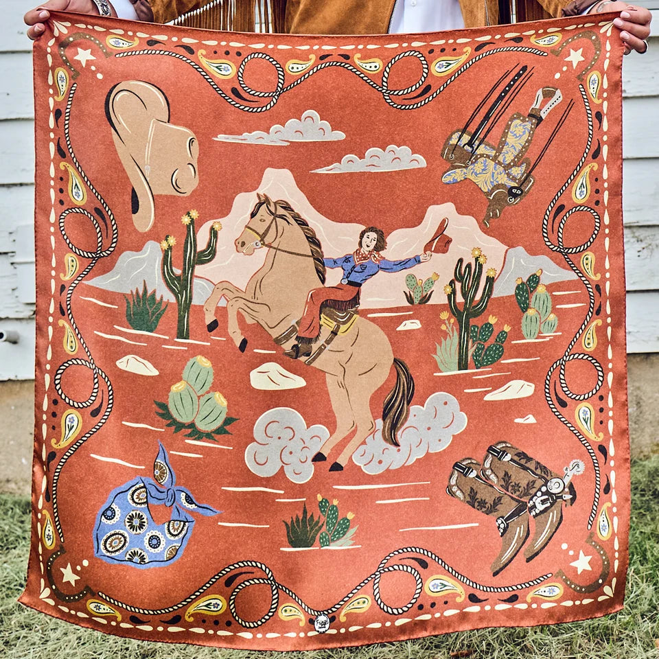 Happy Trails Wild Rag held outstretched showing full retro cowgirl on horseback design in cayenne, cream, and black