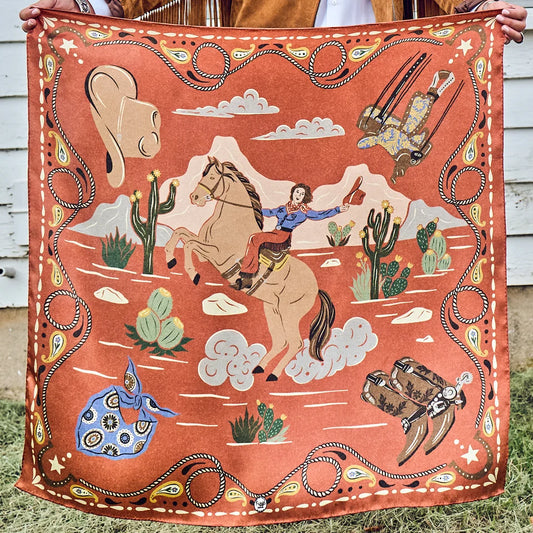 Happy Trails Wild Rag held outstretched showing full retro cowgirl on horseback design in cayenne, cream, and black
