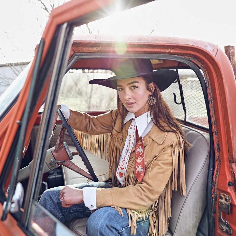 Sweetheart of the Rodeo Twilly in Vintage Red tied around neck in a bow, worn with fringe jacket