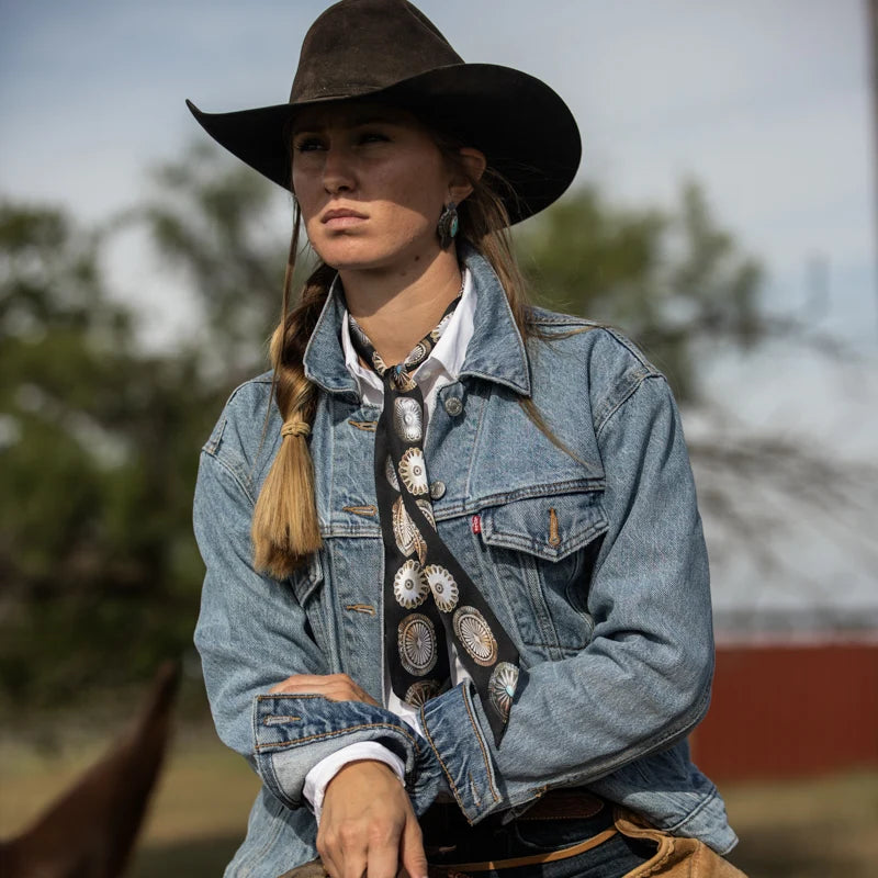 Big Concho Twilly in Black tied around neck over white shirt and denim jacket on horseback
