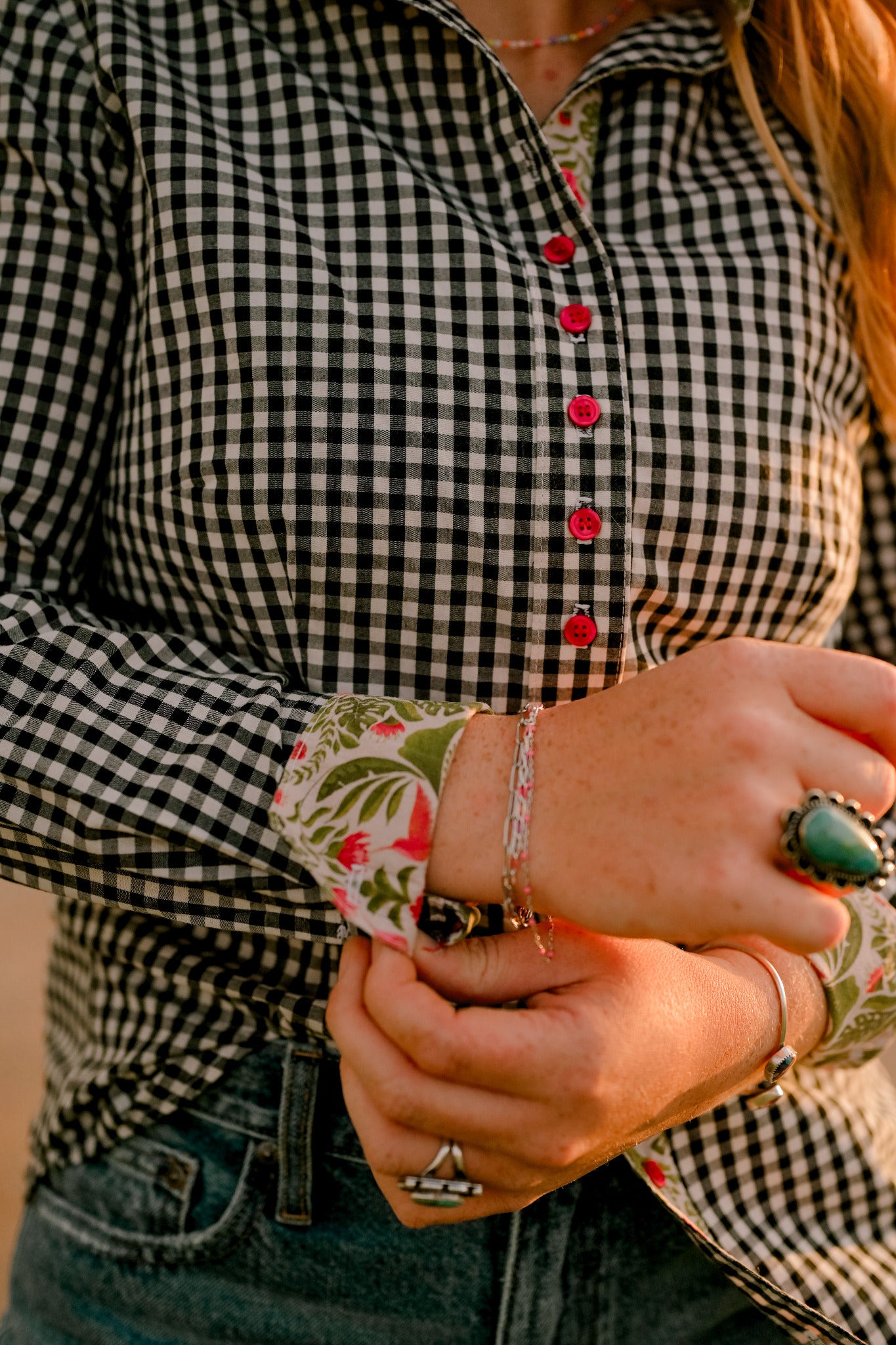 Close-up of a black gingham western shirt sleeve and floral cuff